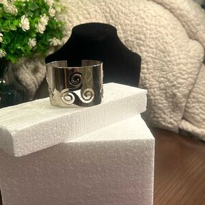Silver-tone wide cuff bracelet with swirly cut-out details